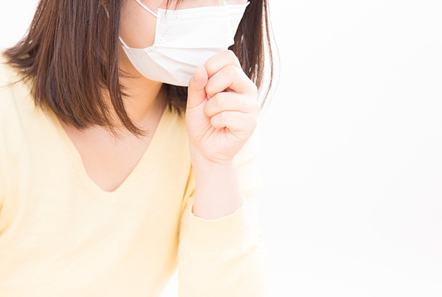 マスクをして咳をする女性