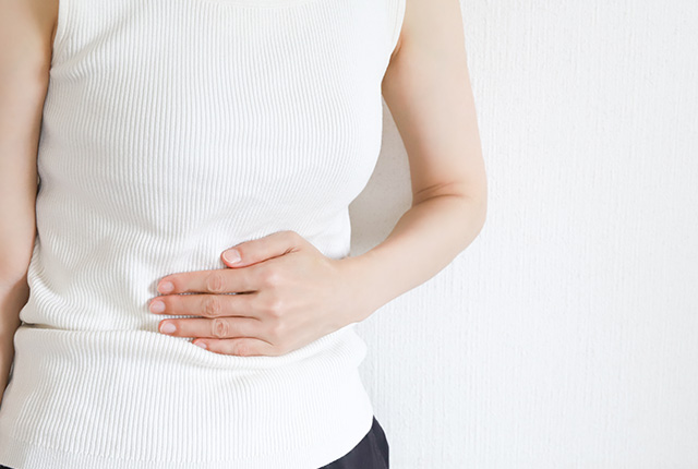 お腹を抑える女性